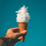 man holding ice cream cone under cloud