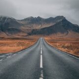 empty highway overlooking mountain under dark skies